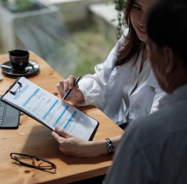 a man and a woman are sitting at a table looking at a resume .