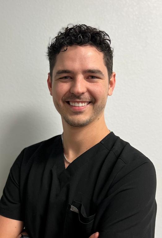 a man wearing a black scrub top with a pocket for a watch