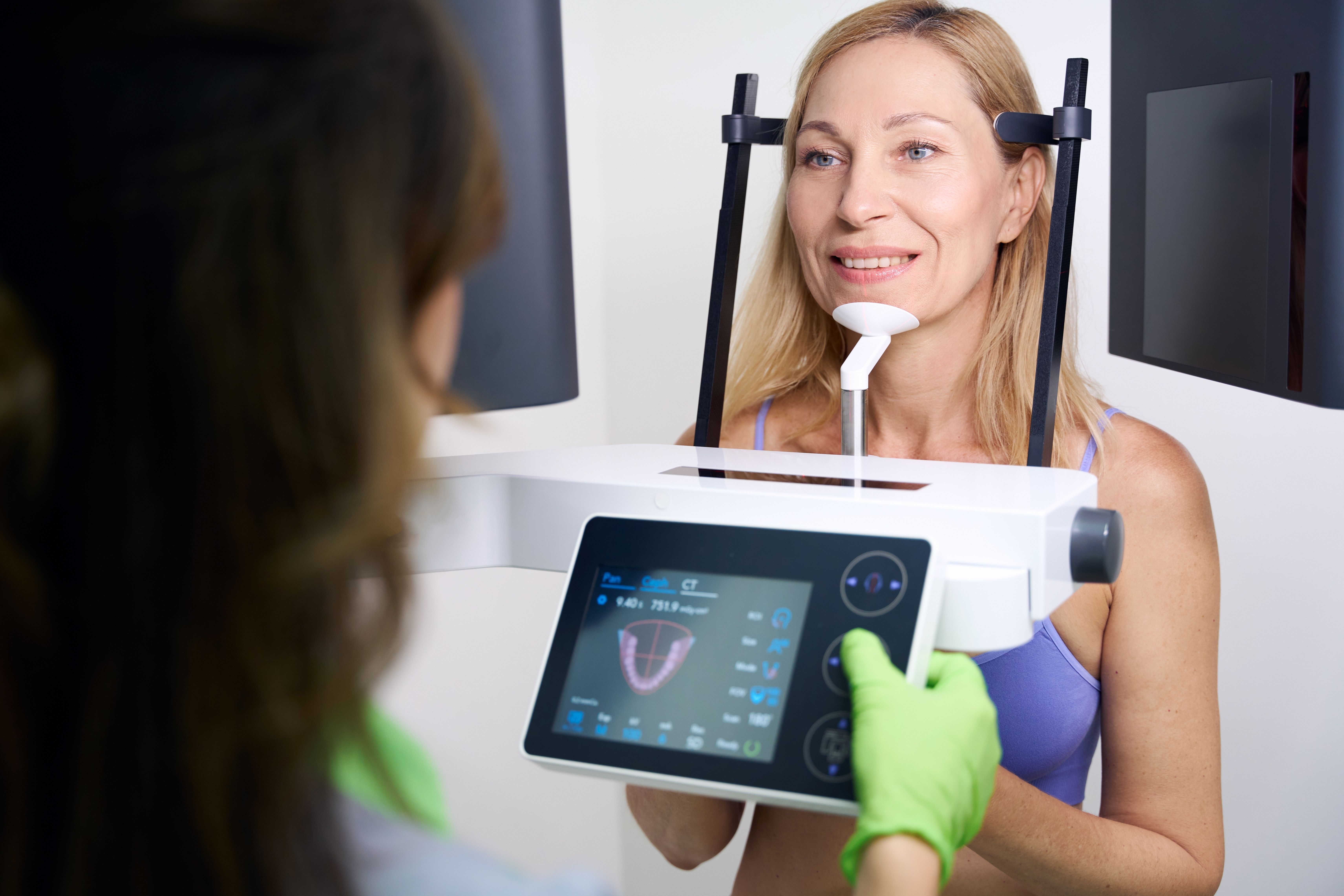 a woman is getting an x-ray of her teeth in a dental office .