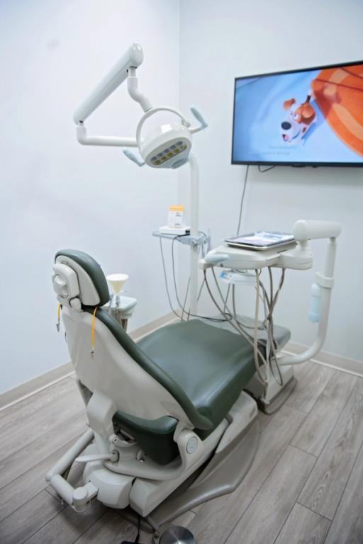 a dental office with a dental chair and a flat screen tv
