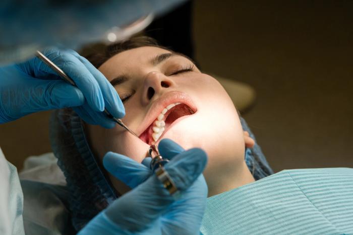 a woman is getting her teeth examined by a dentist .