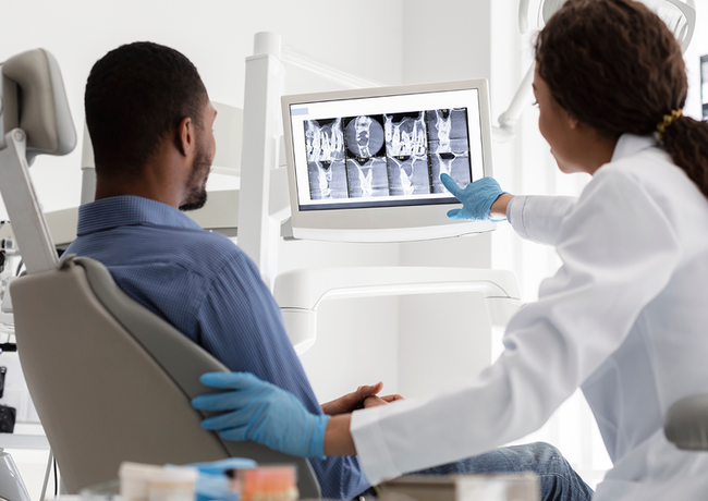 a dentist is showing a patient an x-ray of his teeth