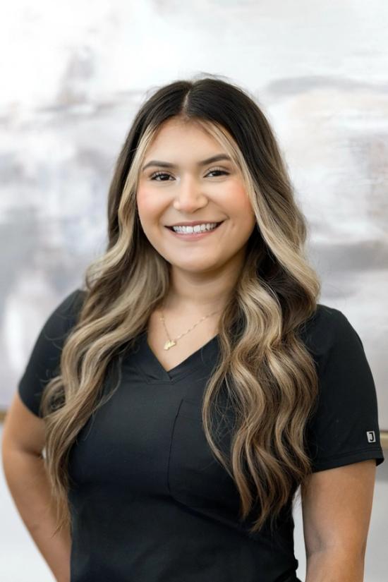 the woman is wearing a black shirt and smiling for the camera .