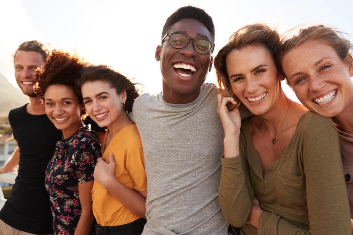a group of young people are posing for a picture together and smiling .