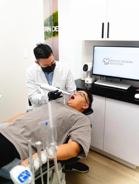 A dentist performs an intraoral scan on a patient in a modern dental office.