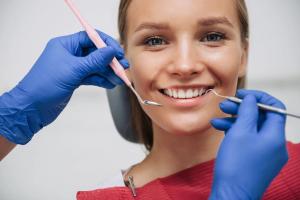 a woman is getting her teeth examined by a dentist .