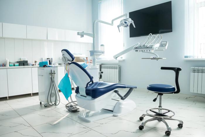 a dental office with a dental chair and a television .