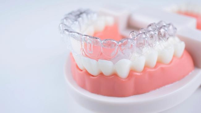 a close up of a model of teeth with a clear brace on it .