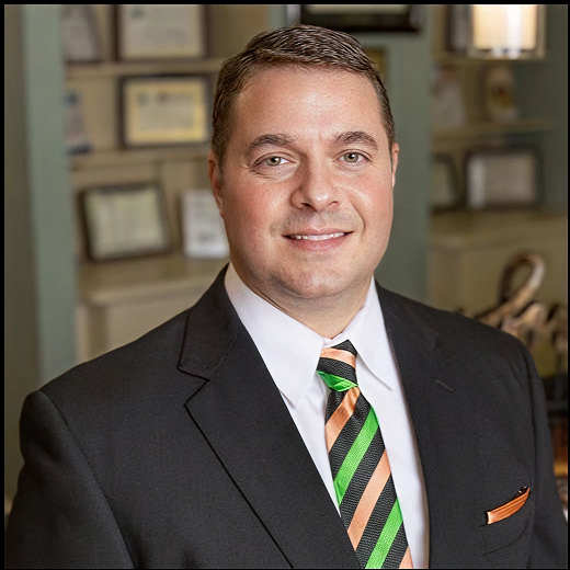 a man in a suit and tie smiles for the camera
