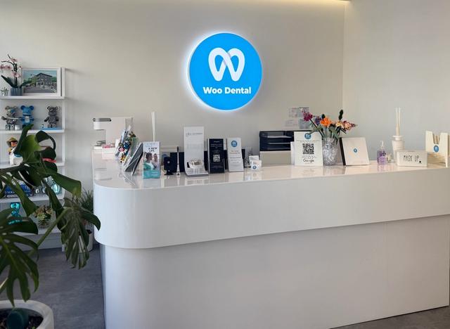 a dental office with a white counter and a blue sign on the wall .