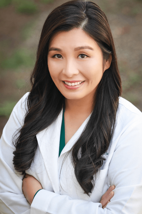 a woman wearing a white lab coat with the letters mc on it