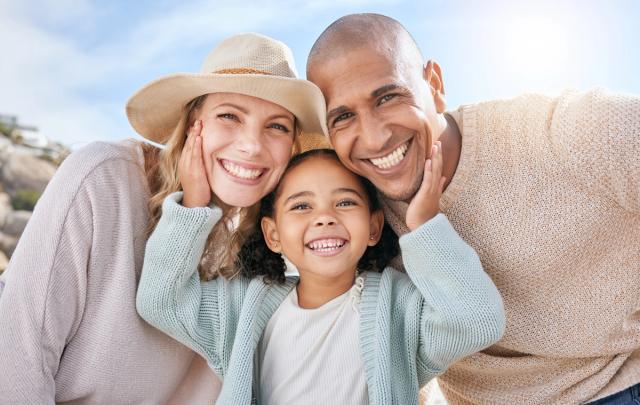 a family is posing for a picture together on the beach .
