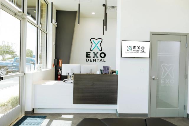 a dental office with a reception desk and a sign on the wall .