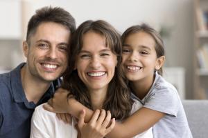 a family is posing for a picture together while sitting on a couch .