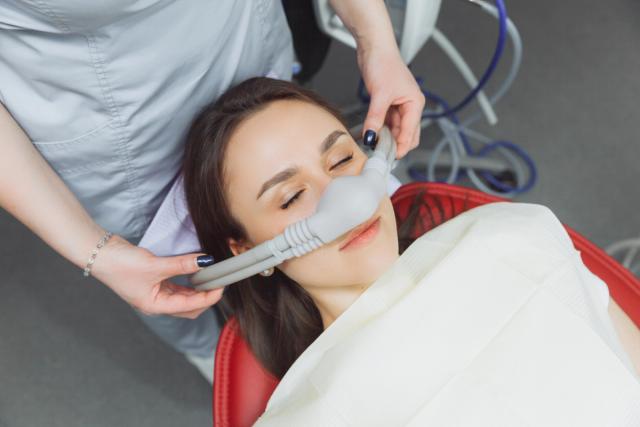 a woman is smiling while sitting in a dental chair .