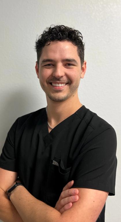 a man wearing a black scrub top with a pocket for a pen