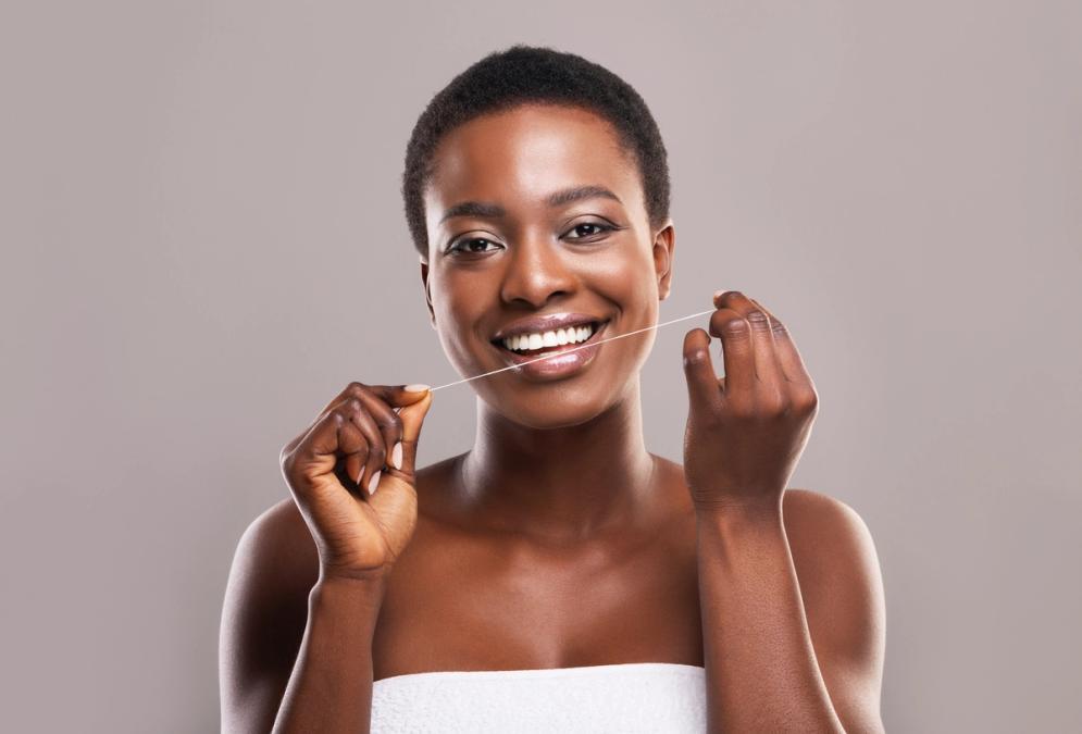 a woman is flossing her teeth with a dental floss .