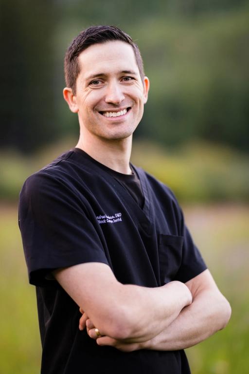 a man wearing a black scrub top with the name andrew on it