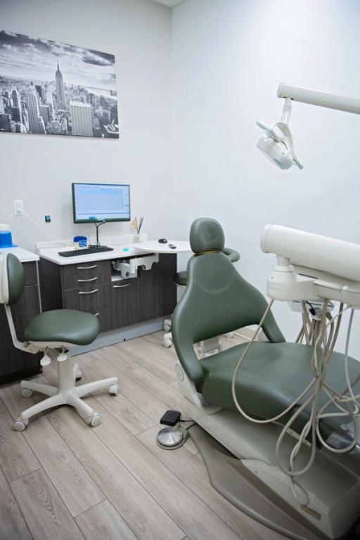 a dental office with a green chair and a computer