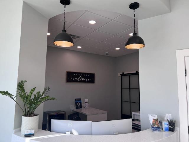 the front desk of a dental office with a sign on the wall that says `` welcome '' .