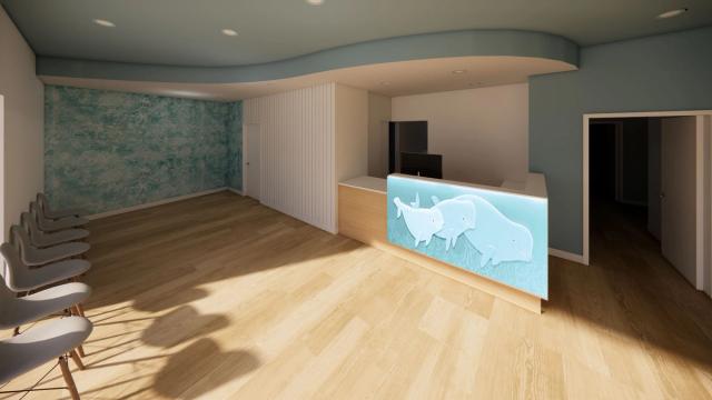 A modern waiting room with a teal accent wall, light wood floor, gray chairs, and a reception desk featuring an illuminated rhinoceros design.