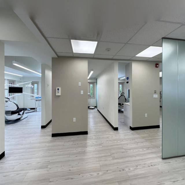 a dental office with a row of dental chairs and a glass wall .