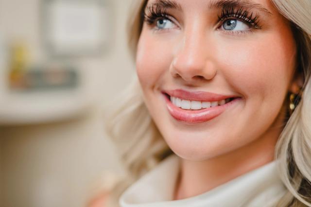 a close up of a woman 's face with a smile on her face .