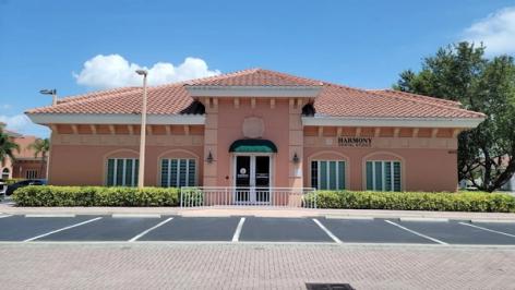a waiting room with a couch , chairs , and a lamp .