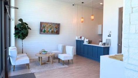 a waiting room with chairs , a table and a counter .