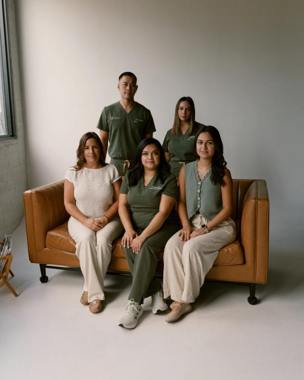 a group of people are posing for a picture while sitting on a couch .