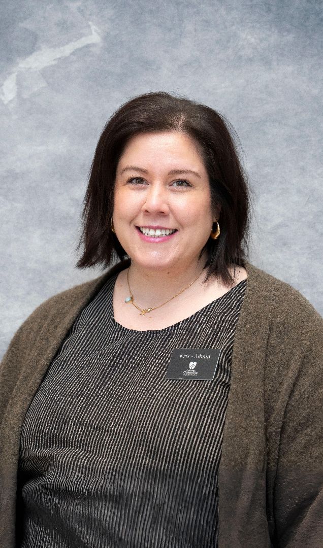 A smiling woman with dark hair and a name tag that reads "Kris - Admin."