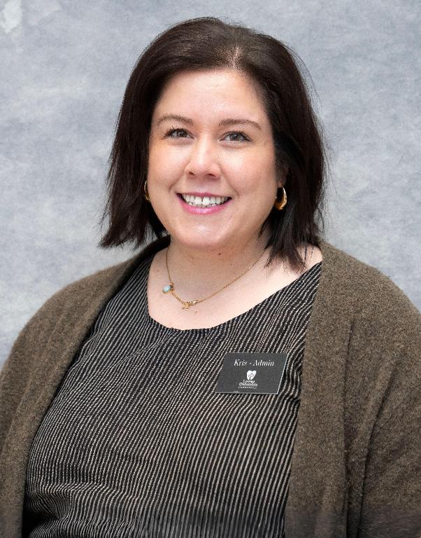 A smiling woman with dark hair and a name tag that reads "Kris - Admin."