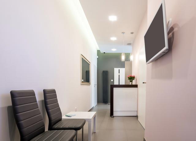 a waiting room with chairs and a flat screen tv on the wall .