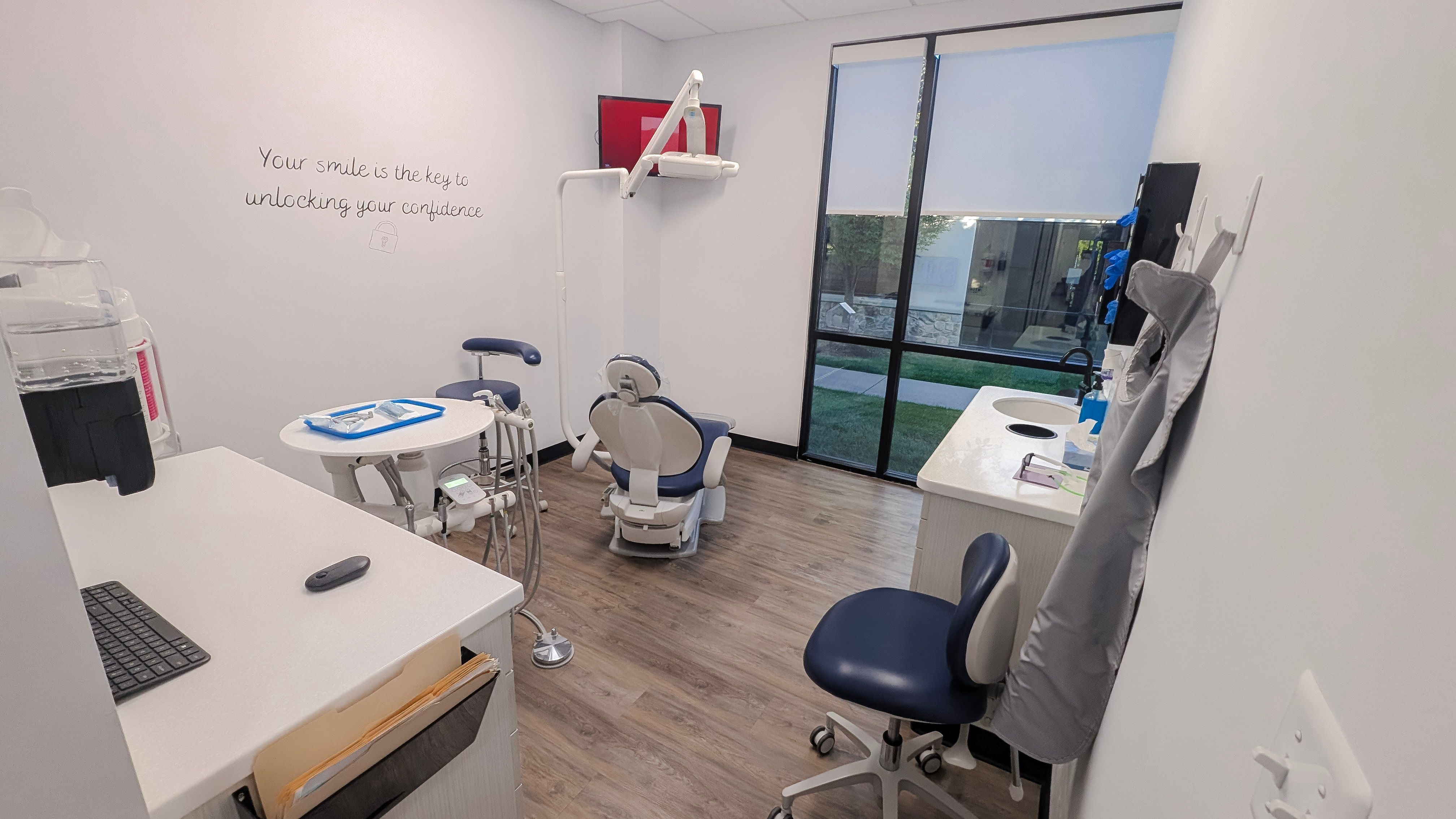 a dental office with two dental chairs , a desk , and a computer .