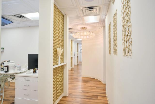 a hallway in a dental office with wooden floors and white walls .