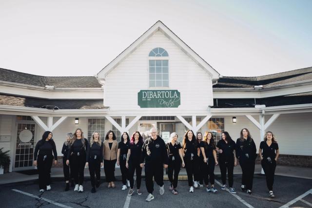 a group of people are standing in front of a building .