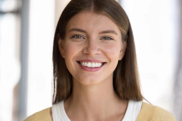 a close up of a smiling woman with white teeth .