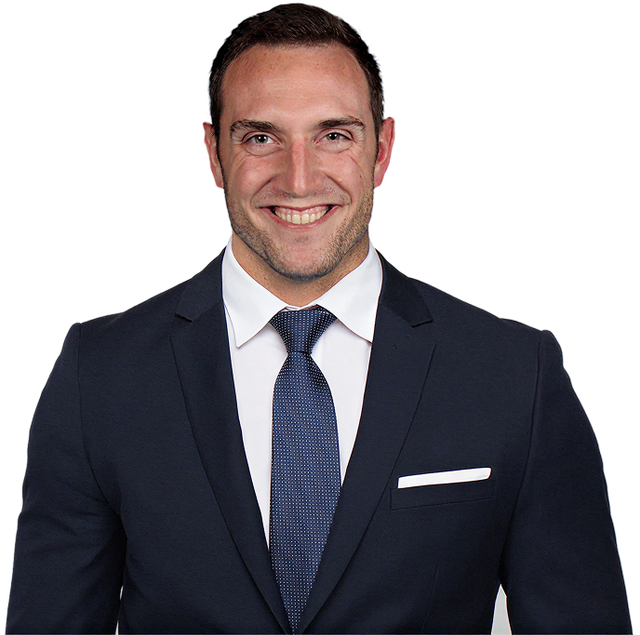 a man in a suit and tie smiles for the camera