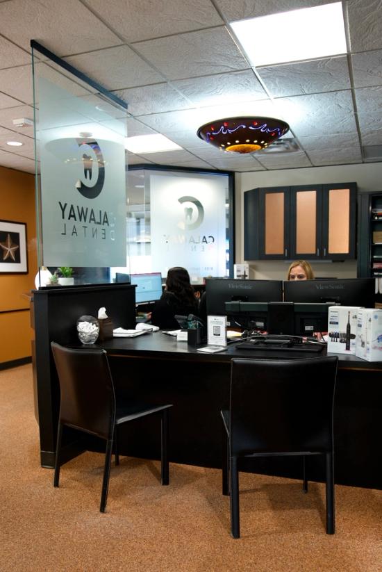 Galaway Dental reception area with two staff members at a dark desk, and the clinic's logo on frosted glass.