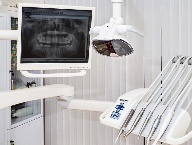 a dental chair with a monitor and dental instruments in a dental office .