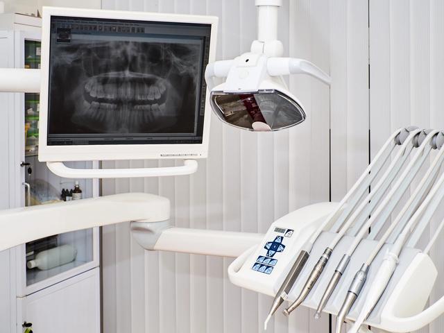 a dental chair with a monitor and dental instruments in a dental office .