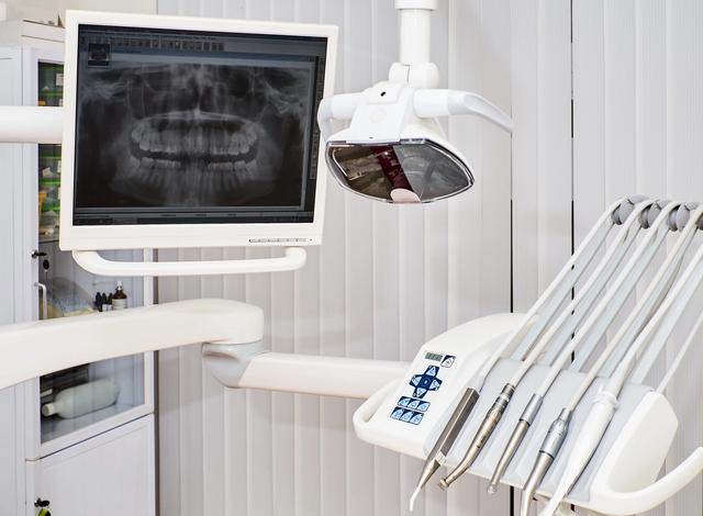 a dental chair with a monitor and dental instruments in a dental office .