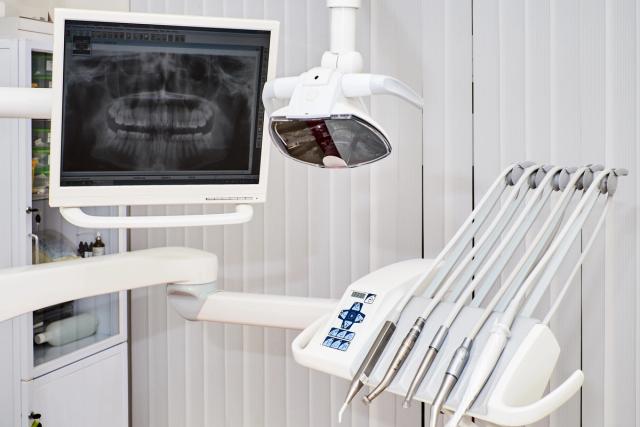 a dental chair with a monitor and dental instruments in a dental office .