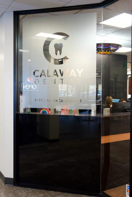 Frosted glass entrance to Calaway Dental with a logo of a 'C' and tooth, text 'Calaway Dental, Austin Calaway DMD,' and a visible 'OPEN' sign.