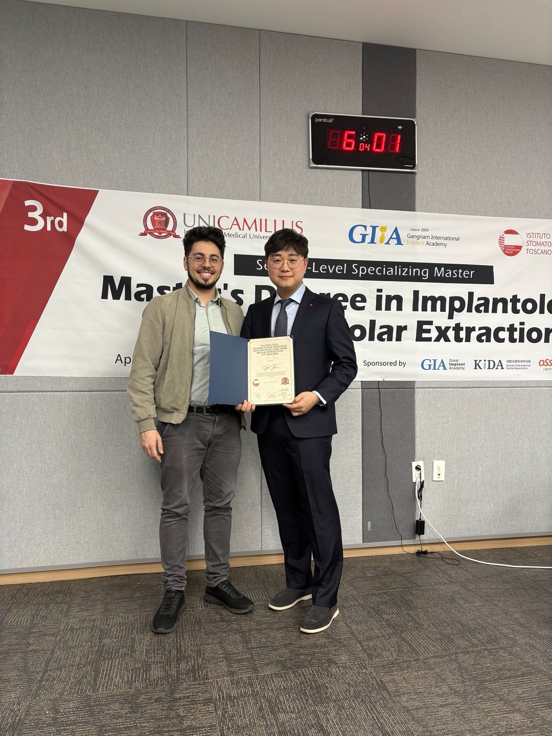 two men standing in front of a banner that says 3rd