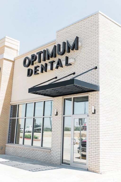 a brick building with a sign that says optimum dental