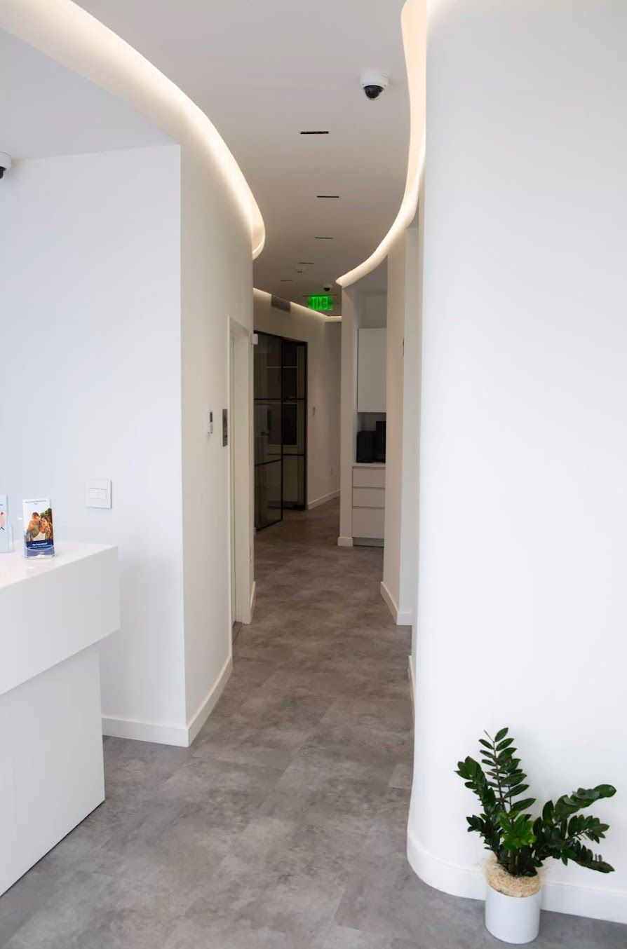 a hallway with a green exit sign on the ceiling