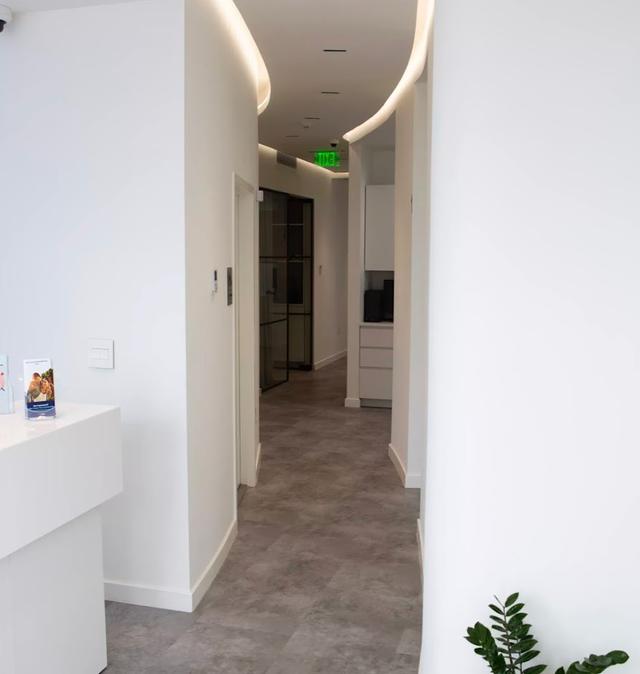 a hallway with a green exit sign on the ceiling