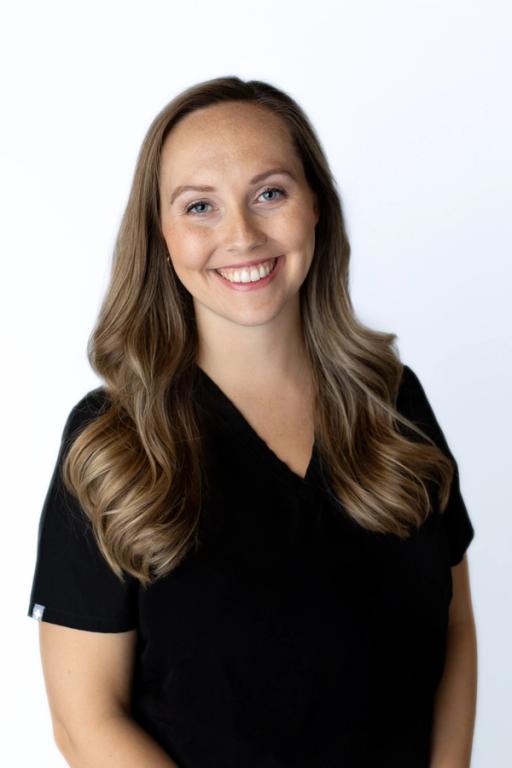 a woman in a black scrub top smiles for the camera