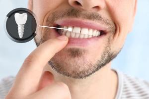 a man is pointing at his teeth with his finger .